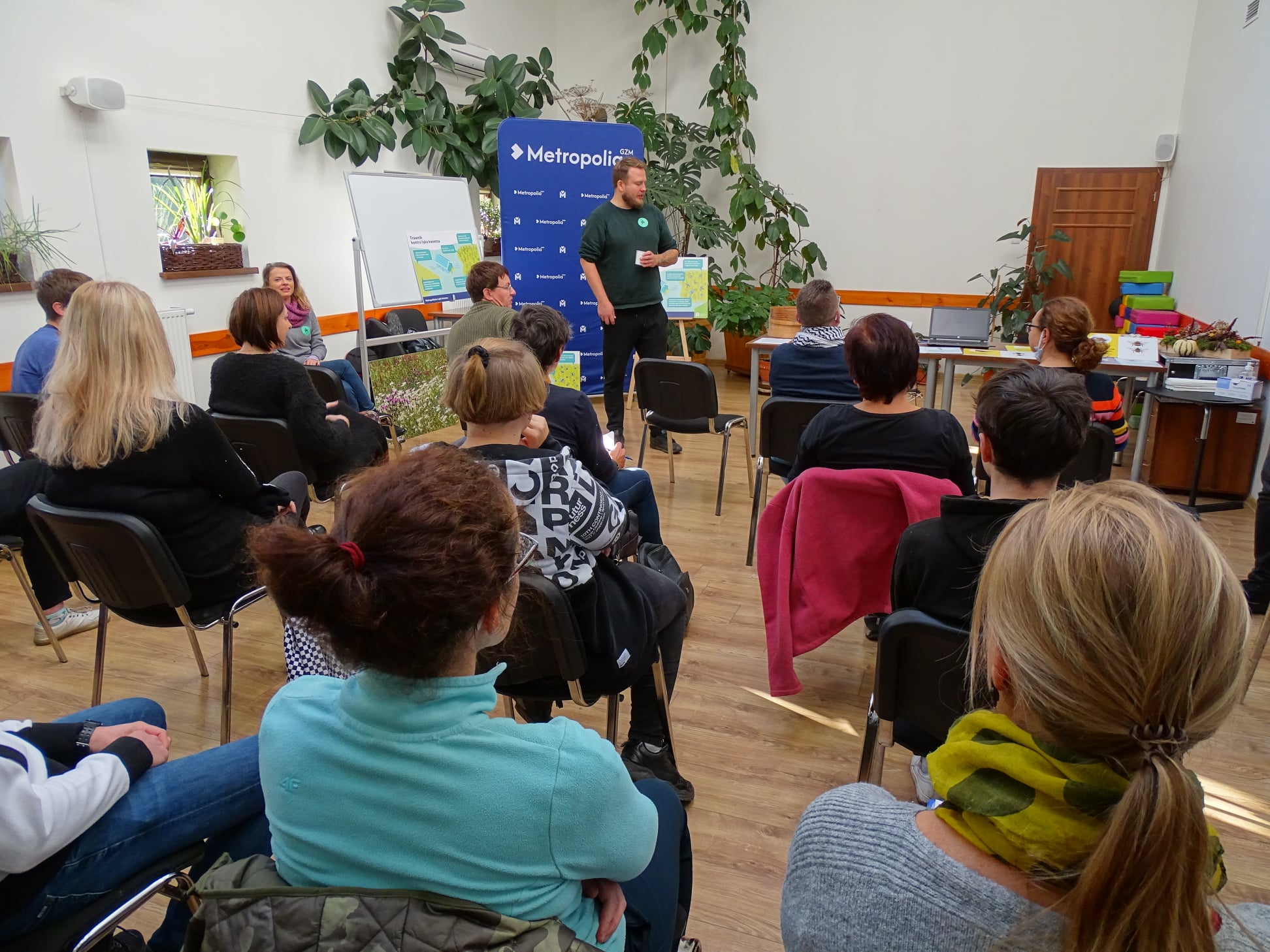 Ludzie słuchają wykładu na warsztatach o łące kwietniej